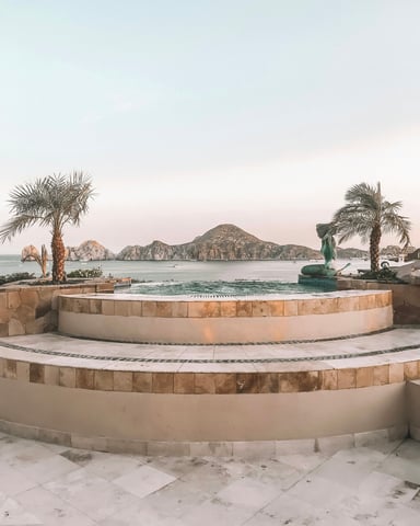 Circular hot tub terrace with El Arco and Cabo San Lucas bay at dusk