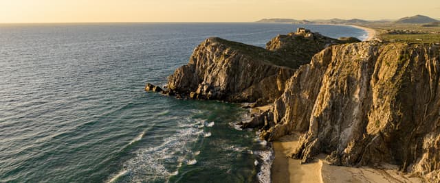 Baja coastline at golden hour with dramatic cliffs and ocean